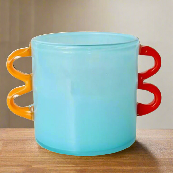 Aqua Blue Glass Vase with Orange Handles
Elevate your space with this stunning handcrafted Aqua Blue Glass Vase, featuring vibrant orange handles. Its unique design adds a pop of color and elegance to any room.Unique Boys.