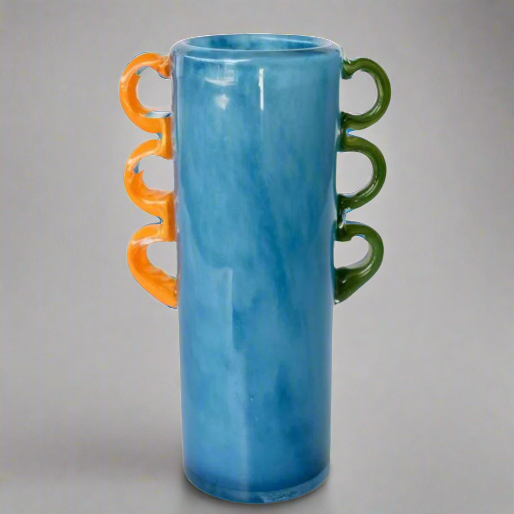 Tall Blue Glass Vase: A Stunning Decorative Piece
Add a pop of color and elegance to your home with our expertly crafted Tall Blue Glass Vase. Featuring vibrant orange and green handles, this unique piece is sure to elevate your interior design. Unique Boys.