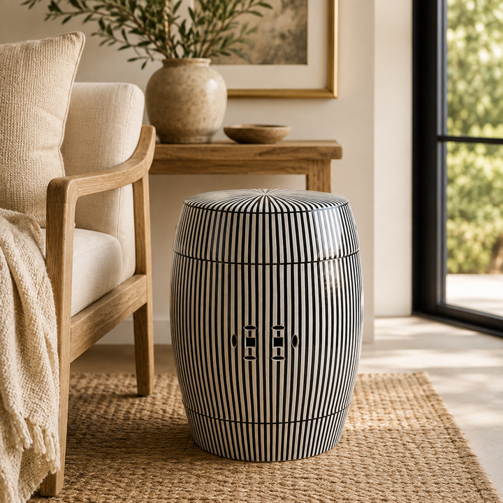 Contemporary glazed ceramic garden stool with bold black and white stripes for elegant interiors.