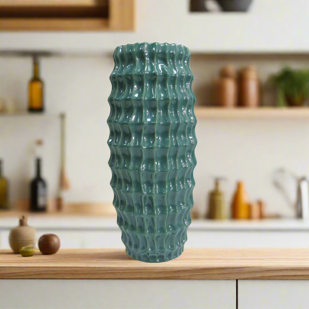 Elevate Your Space with the Stunning Diaspora Vase
Add a touch of elegance and sophistication to any room with the beautiful Diaspora vase. Crafted from high-quality ceramic, this stunning vase boasts a unique, intense teal color with a melted glass look that's sure to impress.
Expertly Crafted
The Diaspora vase is expertly glazed to ensure a long-lasting, beautiful finish. Its perfect size (14cm D x 32cmH) makes it ideal for showcasing long-stemmed greenery, branches, or flowers, adding a touch of natural 