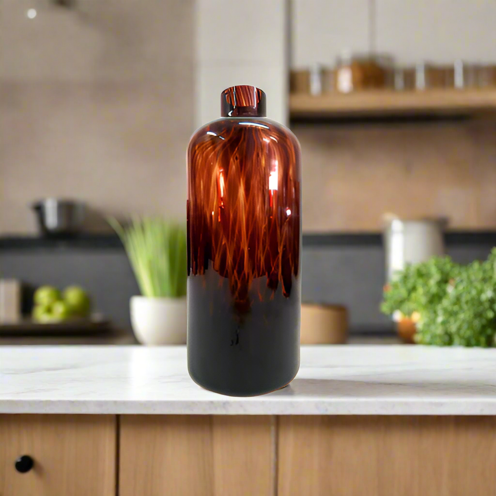 Introducing the Exquisite Oro Vase from Unique Boys
Elevate your home decor with this stunning, one-of-a-kind Oro Vase, expertly crafted with a mesmerizing tortoise shell design glass. Its unique jar/bottle shape adds an air of sophistication, making it a perfect conversation starter for any living space.