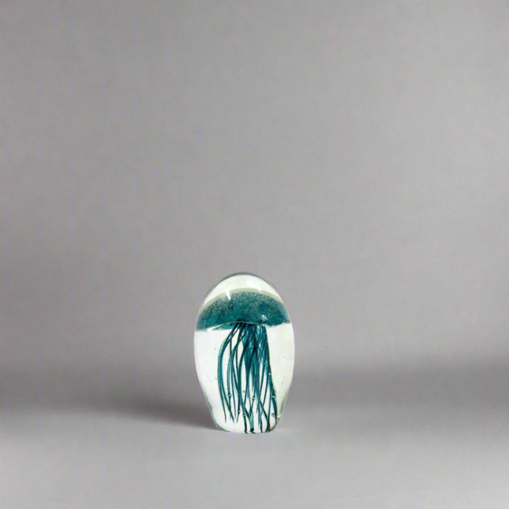 Mejello 9.8cm: A Glowing Masterpiece of Glass Art
Elevate your home decor with the Mejello 9.8cm, a breathtaking handmade clear orb featuring a mesmerizing teal jellyfish shape. Suspended within the glass are delicate silver bubbles and tentacles, adding an extra layer of depth and visual interest.