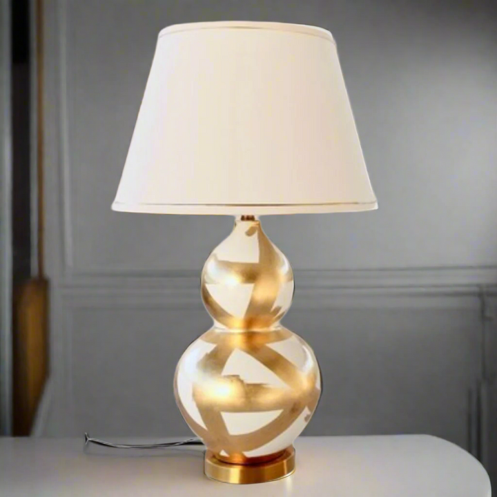 Off White &amp; Gold Painted Lamp Base With Gold Trim Shade 75X45cm
Elevate your home decor with our stunning Off White &amp; Gold Painted Lamp Base With Gold Trim Shade. This unique lamp features a beautifully painted off-white base paired with a luxurious gold trim shade, creating a sophisticated and elegant ambiance perfect for relaxing or entertaining. Measuring 75cm in height and 45cm in width, this lamp is perfectly sized for living rooms, bedrooms, or offices. Unique Boys.