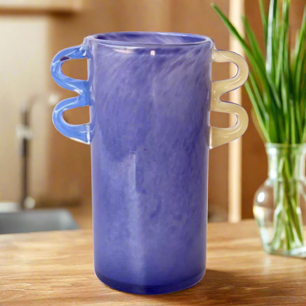 Purple Glass Vase with Blue &amp; Yellow Handles
Elevate your home decor with this stunning Purple Glass Vase, featuring striking blue and yellow handles. Its unique design and high-quality glass construction make it perfect for showcasing floral arrangements or as a standalone decorative piece. Unique Boys.