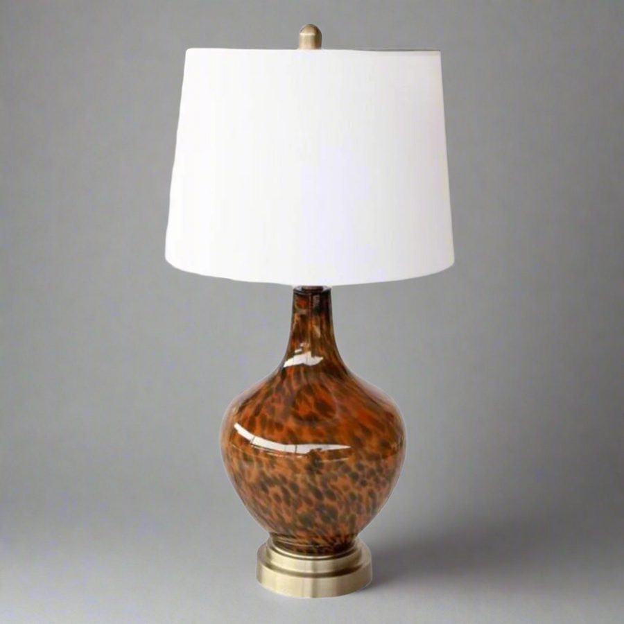 Elevate your home decor with our exquisite Elegant Tortoiseshell Lamp Base, a masterpiece of design and functionality. This stunning piece is expertly crafted to add a touch of sophistication and glamour to any room, making it a perfect addition to your living space.
The lamp base features a unique and rich tortoiseshell design, with intricate patterns that evoke a sense of luxury and refinement. The sleek white finial and harp shade provide a clean and crisp finish, perfectly complementing the warm, earth.