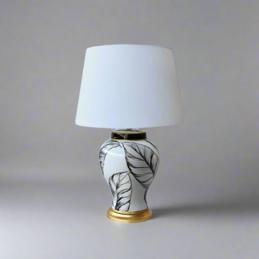 Unique Boys White &amp; Black Leaf Lamp Base
Elevate your space with our stunning White &amp; Black Leaf Lamp Base, expertly handcrafted for elegance and sophistication. The classic leaf design in white and black is paired with a beautiful off-white shade, creating a harmonious balance. Made from high-quality materials, this 65x44cm lamp base is durable and long-lasting. A true statement piece that adds a timeless touch to any room. Unique Boys.
