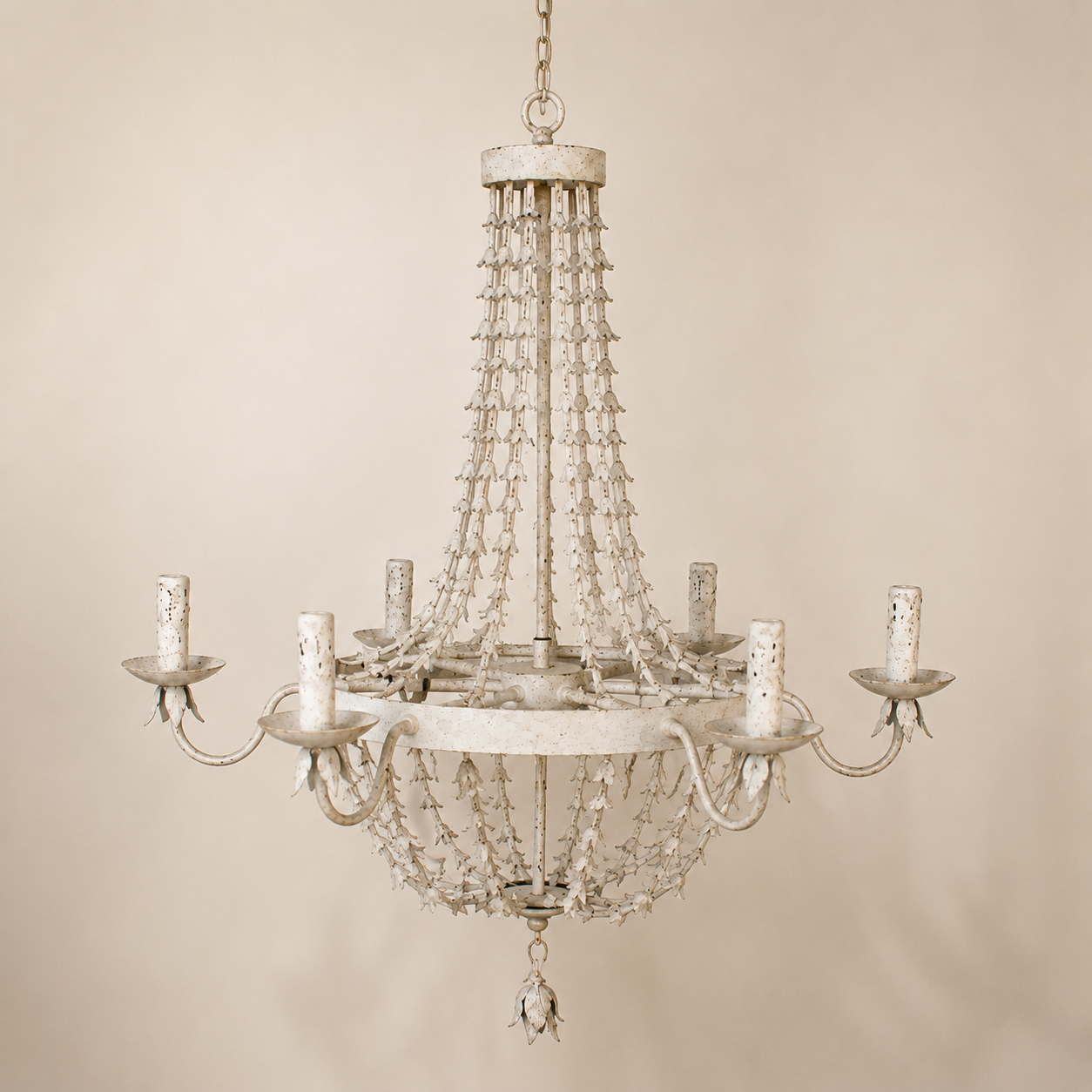 Antique white distressed metal petal six-light chandelier on a warm ivory background