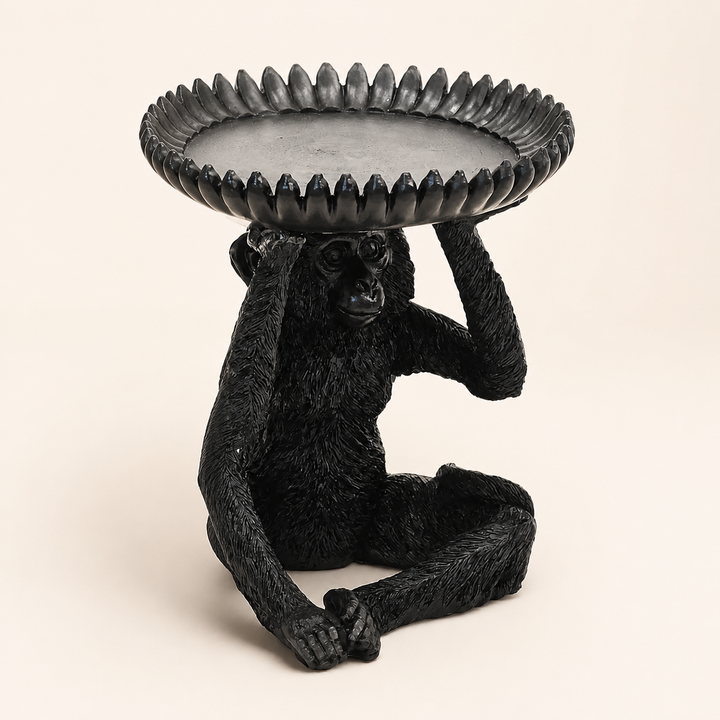 Large black resin monkey banana bowl on warm ivory background