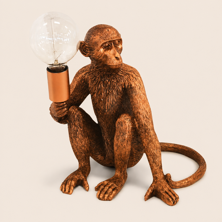 Copper monkey torch table lamp on warm beige background