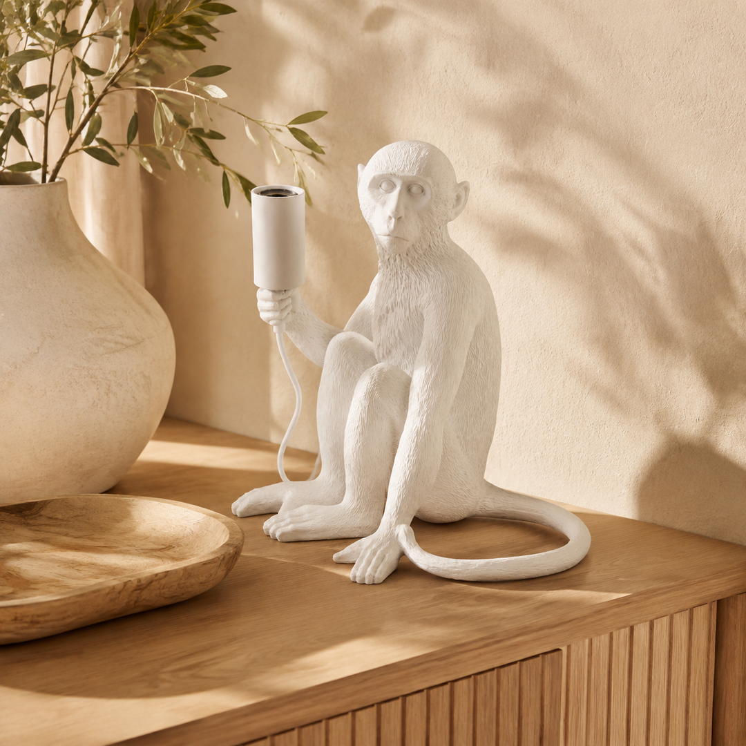 White resin monkey lamp excluding globe in a warm luxury interior