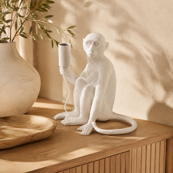 White resin monkey lamp excluding globe in a warm luxury interior