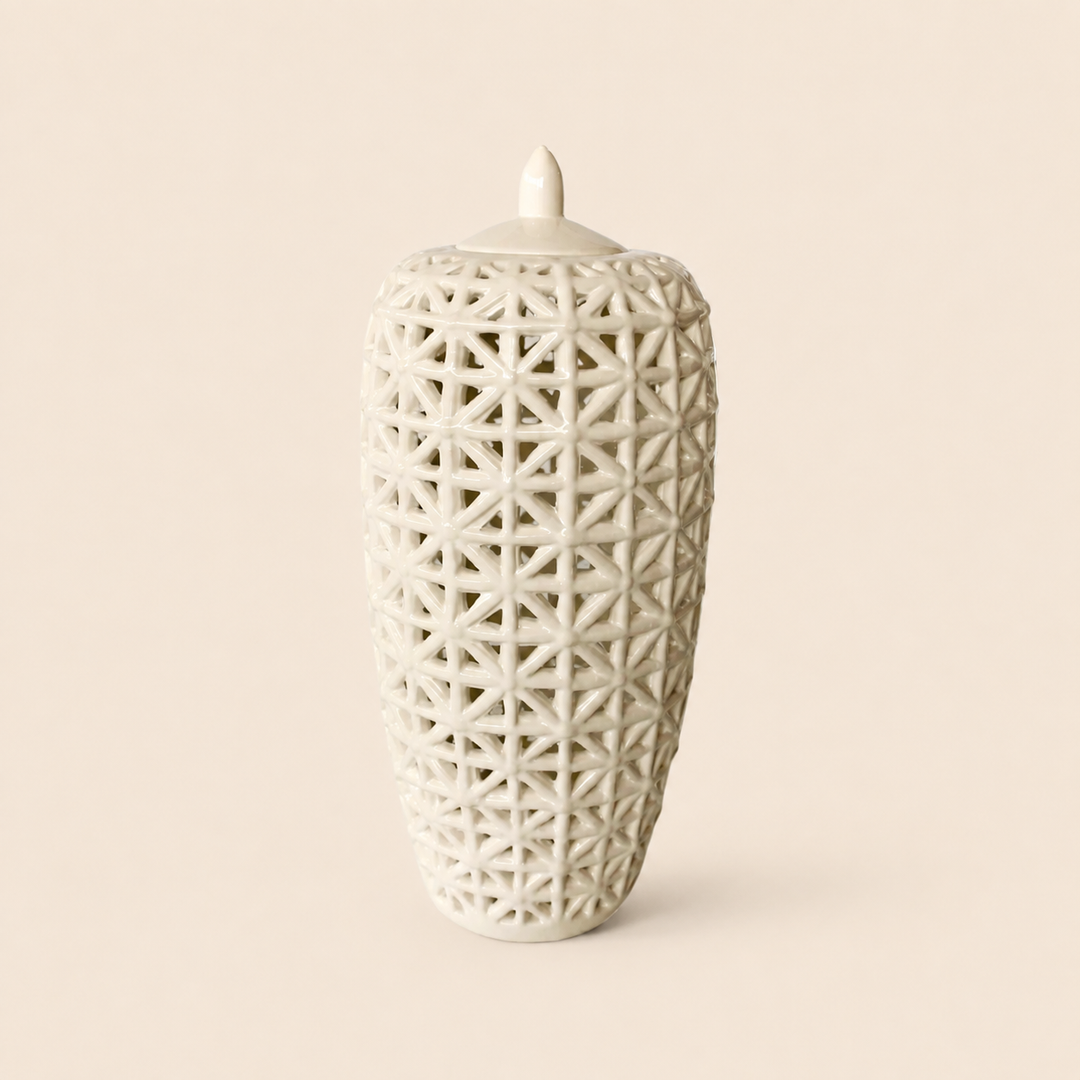 Tall white criss-cross cut-out jar with lid on warm beige background
