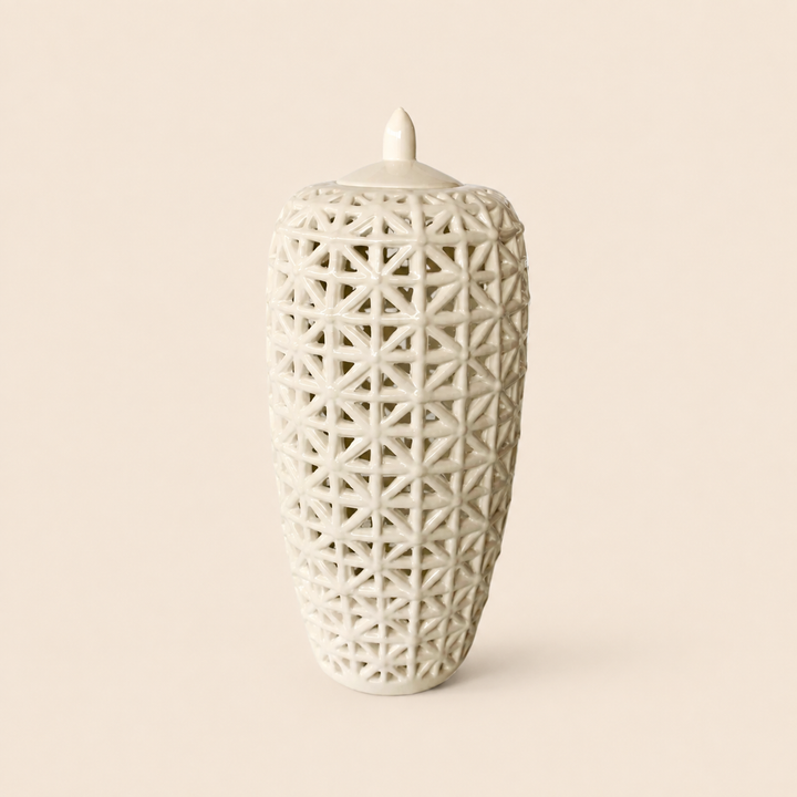 Tall white criss-cross cut-out jar with lid on warm beige background