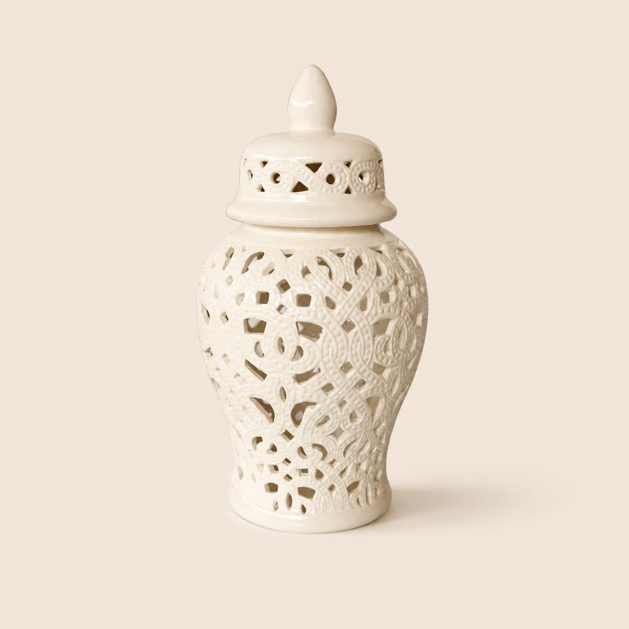 White cut-out ginger jar with braided design on warm beige background
