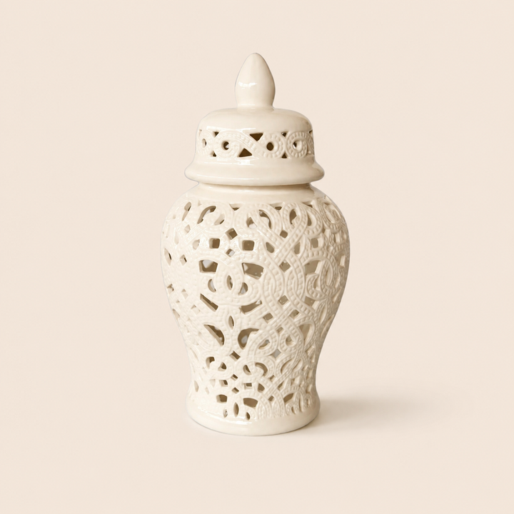 White cut-out ginger jar with braided design on warm beige background