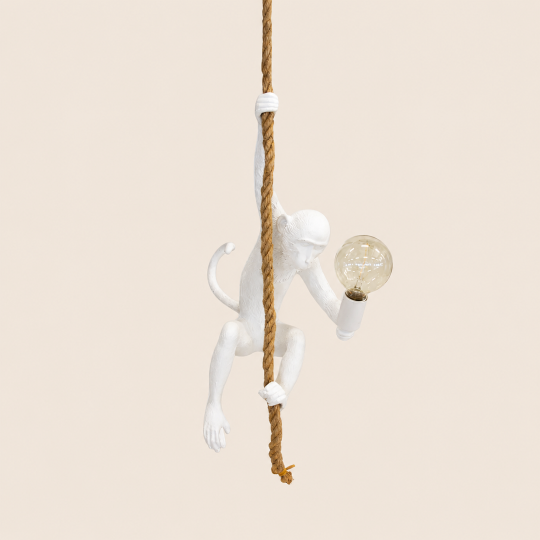 White resin monkey on rope hanging lamp on warm beige background