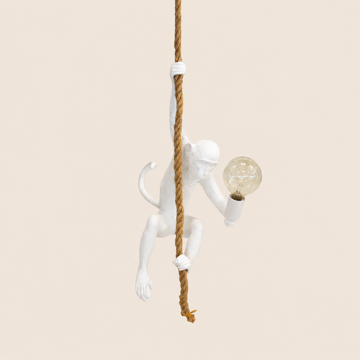 White resin monkey on rope hanging lamp on warm beige background
